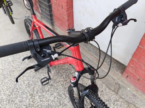 Close-up of mountain bike handlebar with gear shifter and brake lever.