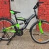 Black and green mountain bike with full suspension for off-road riding.