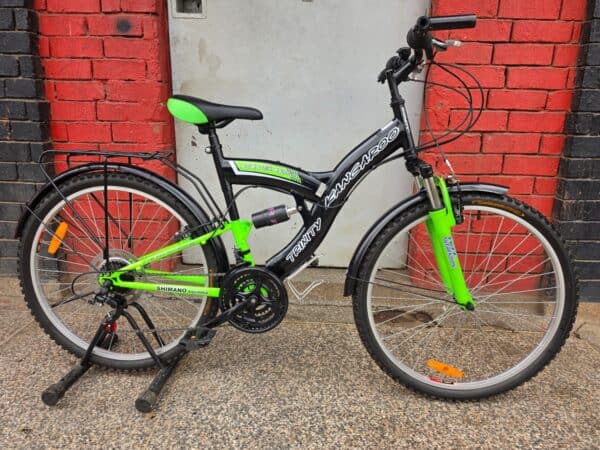 Black and green mountain bike with full suspension for off-road riding.