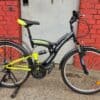 Full suspension mountain bike with black and yellow frame for off-road riding.